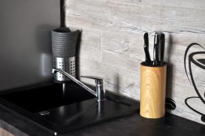 um balcão de cozinha com um lavatório e um suporte para escovas de dentes em Q Apart Gold-3 Pokoje, Garaż, Netflix, Klimatyzacja, FV, em Lódź