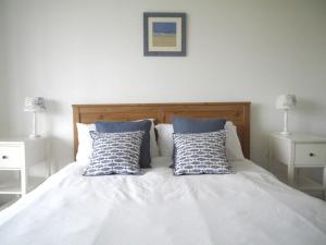 a white bed with two pillows on top of it at Bay View, Port Isaac in Port Isaac