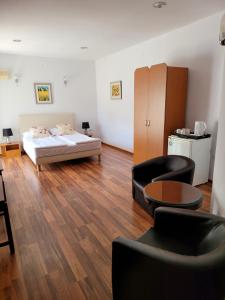 a living room with a bed and a table and chairs at Pension Edelweiss in Eforie Sud