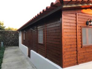 eine Hütte mit Holzvertäfelung an der Seite eines Gebäudes in der Unterkunft A Cabana in Angra do Heroísmo