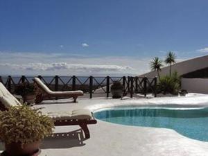 a swimming pool with chairs and a view of the ocean at Villa - Sleeps 8 - Hot Tub - Pool - Parking in Conil +23 photos
