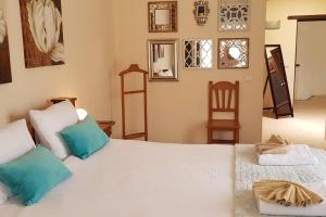 a bedroom with a large white bed with blue pillows at Villa Papaz - cosy spacious sea view pool in Conil