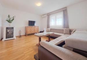 un soggiorno con divano, tavolo e camino di Apartments Branko a Budua