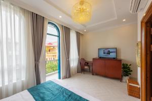 a bedroom with a bed and a television and a window at WHITE HOTEL in Lạng Sơn
