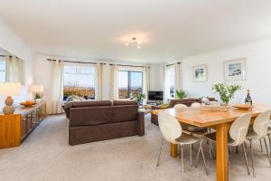 uma sala de estar com uma mesa e um sofá em Beau Vista Ground Floor Apartment em Padstow