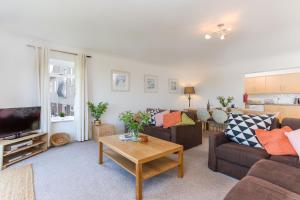 a living room with two couches and a table at Beau Vista Ground Floor Apartment in Padstow