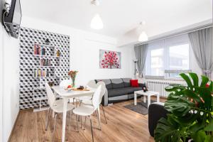 a living room with a table and chairs and a couch at Apartamenty Niko in Zator