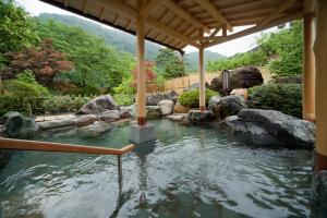 a pool of water with rocks in a garden at Yumetsuzuri in Omaki