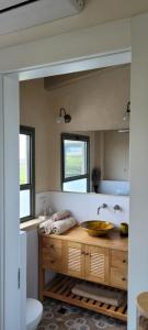 ein Badezimmer mit einem Waschbecken und einem großen Spiegel in der Unterkunft צימר חלון לרקפות zimer Window for primroses עם ג'קוזי לנוף in Tal Shaẖar