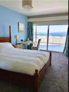 a bedroom with a bed and a view of the ocean at Haven Rooms Sea View at The Blue Haven in Donegal