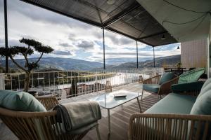 a balcony with chairs and a table and a view at Green House - Douro in Peso da Régua