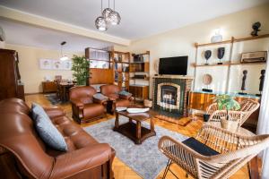 uma sala de estar com um sofá de couro e uma lareira em Green House - Douro em Peso da Régua