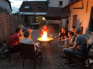 a group of people sitting around a fire in a yard at Enjoytoday 49 - Luxueus familieverblijf aan de voet van de Koppenberg in Oudenaarde