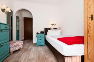 1 dormitorio con cama blanca y cómoda azul en Hotel Garni Effland en Bayrischzell