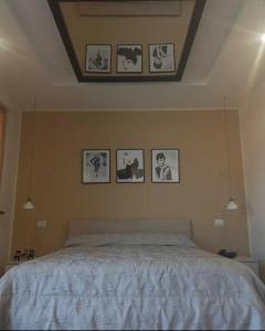 1 dormitorio con 1 cama con cuadros en la pared en Amy Dreams en Ottaviano
