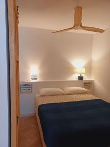 una camera con letto e ventilatore a soffitto di Apto en 1ra línea Carrer Les Voltes Parking Grátis a Calella de Palafrugell
