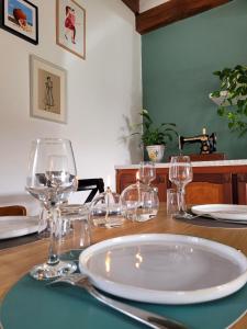 una mesa con copas de vino y un plato en ella en L Amalia au cœur des Châteaux de la Loire et du zoo de Beauval, en Sambin