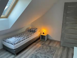 a bedroom with a bed and a lamp on a floor at Apartamenty i Pokoje DIMAN in Mrągowo