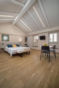 a large bedroom with a bed and a desk in it at Le Case di Angelina - Langhe Loft & Suites in Farigliano