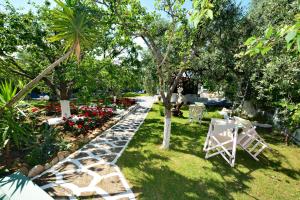 a garden with a path and a table and chairs at Villa Emilia in Pachis +11 photos