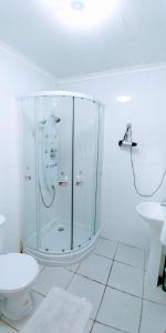 a bathroom with a shower and a toilet and a sink at Furnished Apartment Cabaas del Profe in Puerto Montt