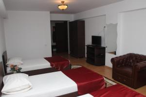 a hotel room with two beds and a chair at Hotel Royal 2 in Urziceni