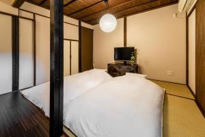 Giường trong phòng chung tại Kohaku an Machiya House
