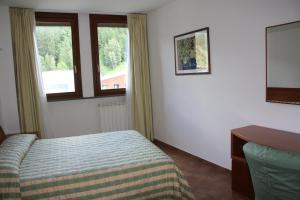 a hotel room with a bed and a window at Appartamenti Campo Smith in Bardonecchia