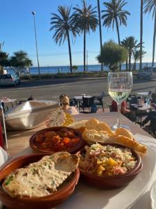 einen Tisch mit einem Teller Essen und einem Glas Wein in der Unterkunft Casa Kelly in Puerto de Mazarrón