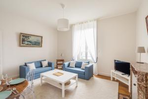 a living room with two blue chairs and a table at LE SEIZE - Appartement spacieux au cœur d'un quartier calme de Rennes in Rennes