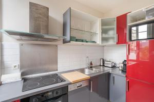 a kitchen with red and white appliances and a red refrigerator at LE SEIZE - Appartement spacieux au cœur d'un quartier calme de Rennes in Rennes