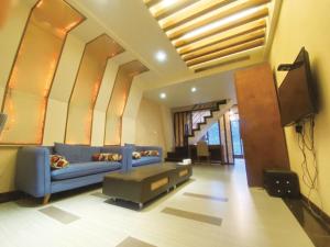uma sala de estar com um sofá azul e uma televisão em Jiaoxi Guanjinglou Hot Spring Club em Jiaoxi
