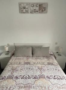 1 dormitorio con 1 cama con 2 lámparas y 2 cuadros en la pared en Apartamento El Jazmín, en Grazalema