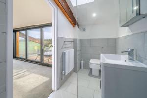 a bathroom with a toilet and a sink and a window at Mandalore in Blyford +23 photos
