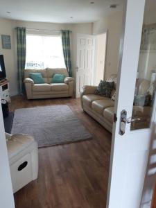 a living room with two couches and a window at 10 Clara Meadows in Culdaff