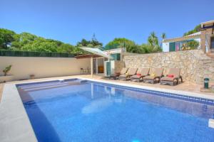 a swimming pool with chairs next to a house at Casa da Horta in Almancil