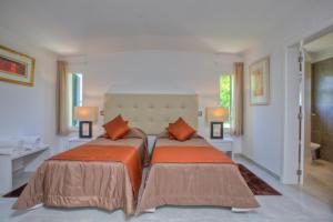 a bedroom with two beds with orange pillows at Casa da Horta in Almancil +8 photos
