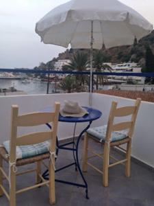 
a table topped with a umbrella and chairs at Sofia Rooms in Loutro
