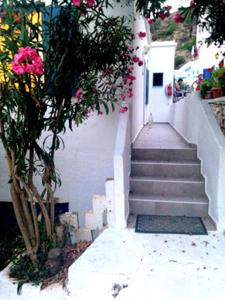 
a staircase leading up to a balcony with a bunch of flowers in it at Sofia Rooms in Loutro
