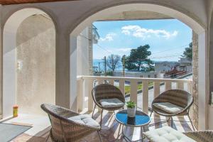 eine Terrasse mit Stühlen und einem Tisch auf dem Balkon in der Unterkunft Apartments Clarus Mare in Duće