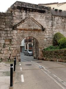 un arco en una pared de piedra con un coche aparcado en Lizarra 49, en Estella