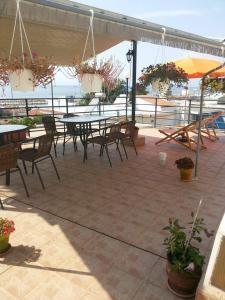 a patio with tables and chairs with the ocean in the background at Anna Georgiou in Skala Sotiros