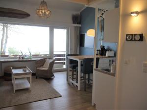 eine Küche und ein Wohnzimmer mit einem Schreibtisch und einem Tisch in der Unterkunft Sea View Lodge in Scharbeutz