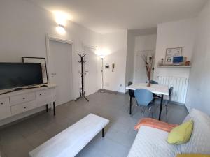 un soggiorno con una TV, un divano e un tavolo di Casa Teatro a Sassari