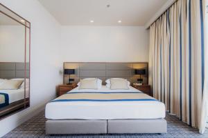 a bedroom with a large bed and a large mirror at Royal Neptun Hotel in Dubrovnik