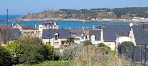 una ciudad con casas y un cuerpo de agua en Côte et Mer, en Erquy