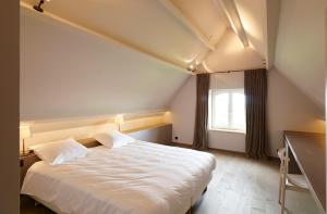 1 dormitorio con cama blanca y ventana en Vacation Home Landgoed de Monteberg, en Dranouter