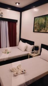 twee bedden in een kamer met handdoeken erop bij Lolo Panding Inn in El Nido