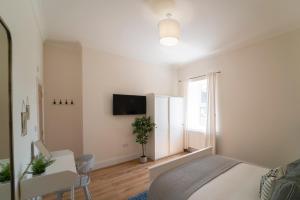 a bedroom with a bed and a tv on a wall at Foundry Farm Apartment in Hexham
