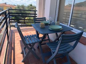 einen blauen Tisch und Stühle auf dem Balkon in der Unterkunft AMSTERDAM 29 - Precioso apartamento para 6 personas in Roses